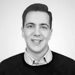 Professional headshot of Andrei Racasan, smiling and dressed in a collared shirt with a dark sweater
